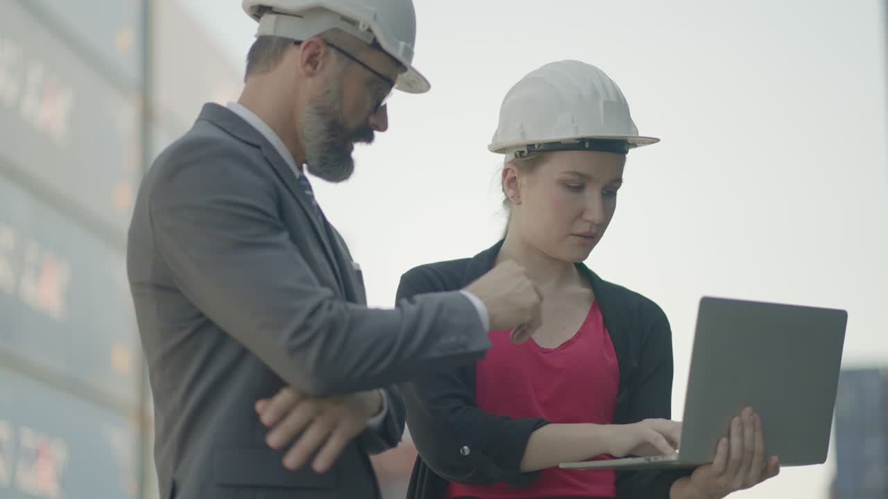 propietario de negocios logísticos, ejecutivo y secretario o asistente, comprobar la carga de carga y el proceso de envío en tiempo real o el progreso del plan de inversión más en el portátil en el patio de contenedores comerciales.