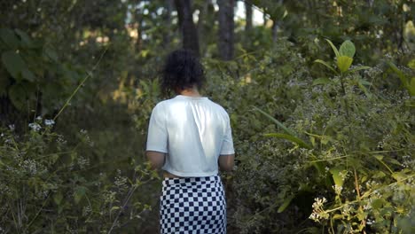 entre los árboles: una niña explorando la naturaleza con una flor