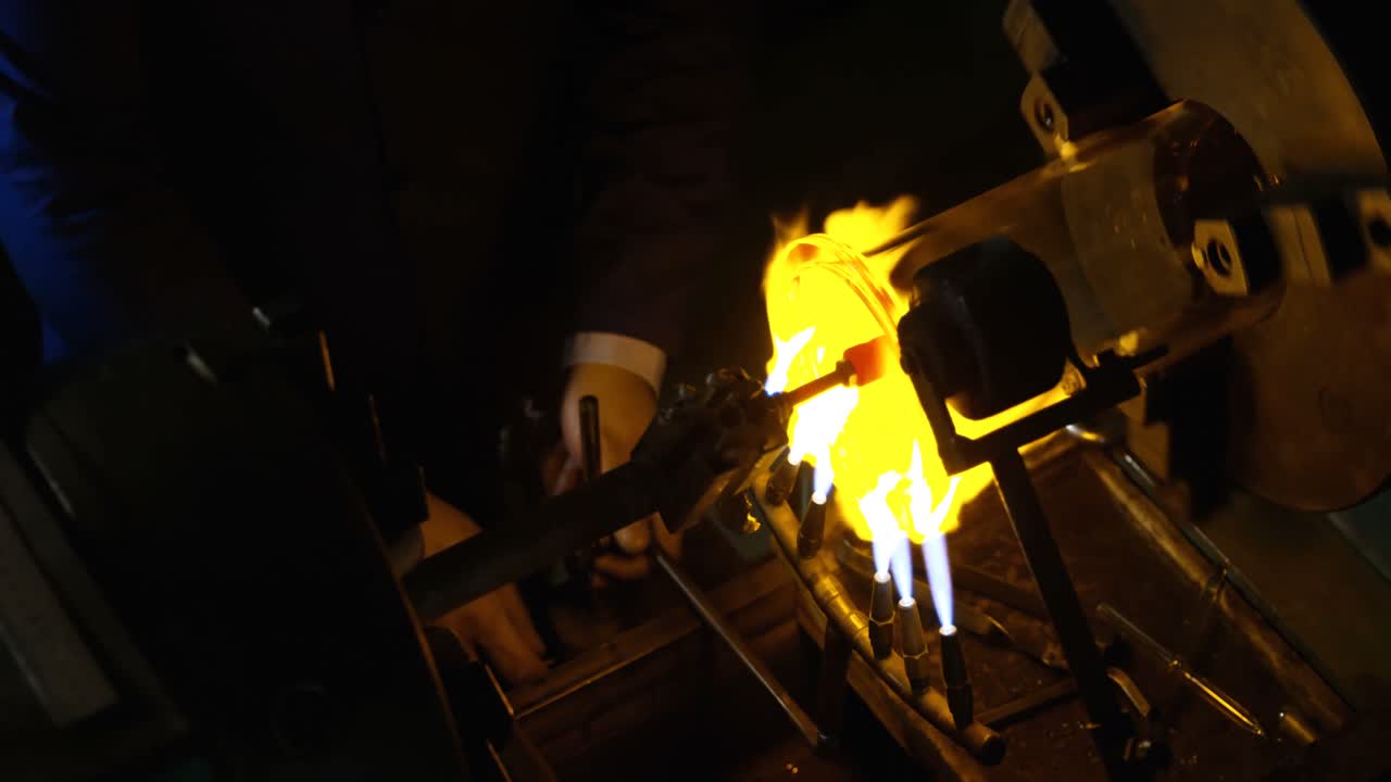 Male worker blowing glass in glass factory 4k