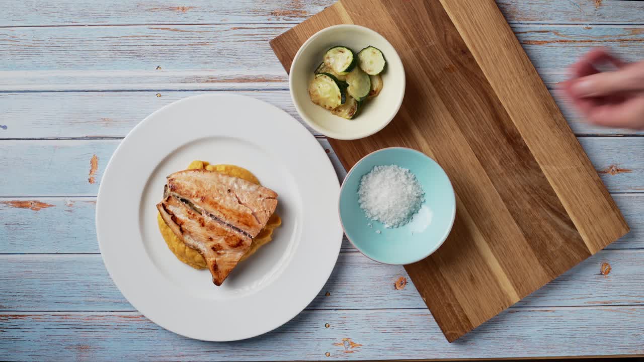 코코넛 밀크와 구운 연어를 곁들인 건강한 으깬 고구마를 제공하는 상위 뷰