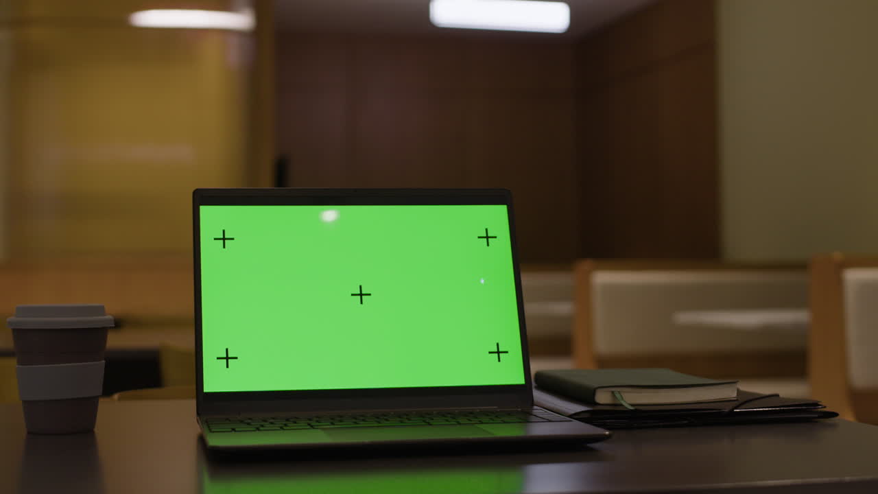 portátil con pantalla verde en un escritorio