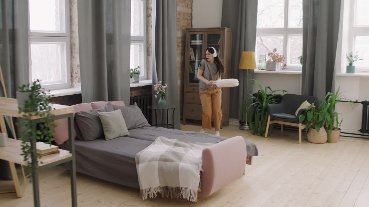 Woman in Headphones Cleaning and Dancing