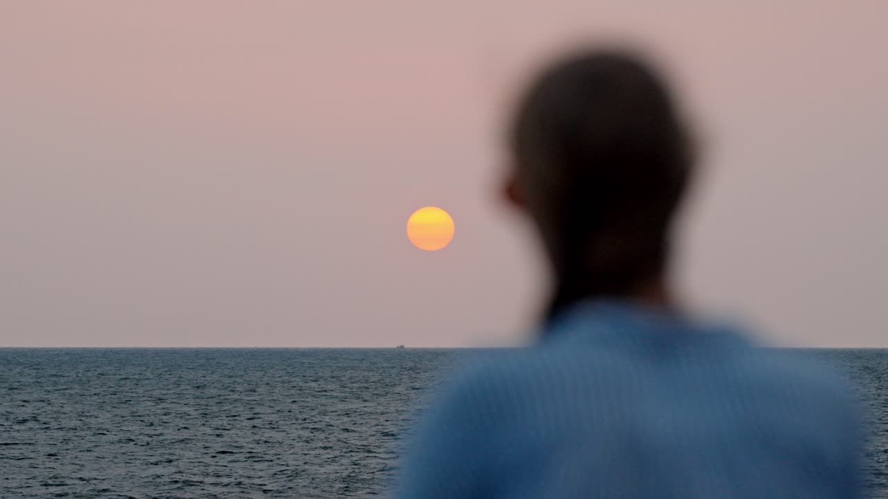 A serene moment in Galle, Sri Lanka, as a woman gazes at the vast ocean during a breathtaking sunset.
