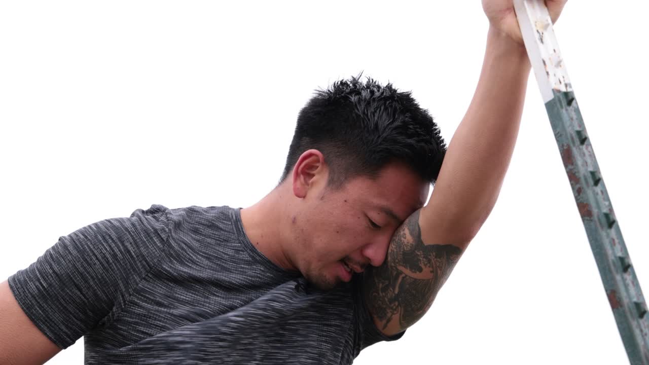 운동 후 극에 기대어 아시아 남성