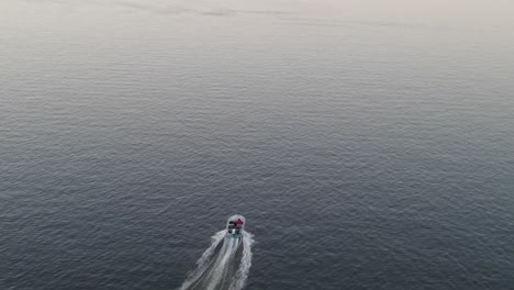 speedboat traveling across calm sea leaving marks on water surface