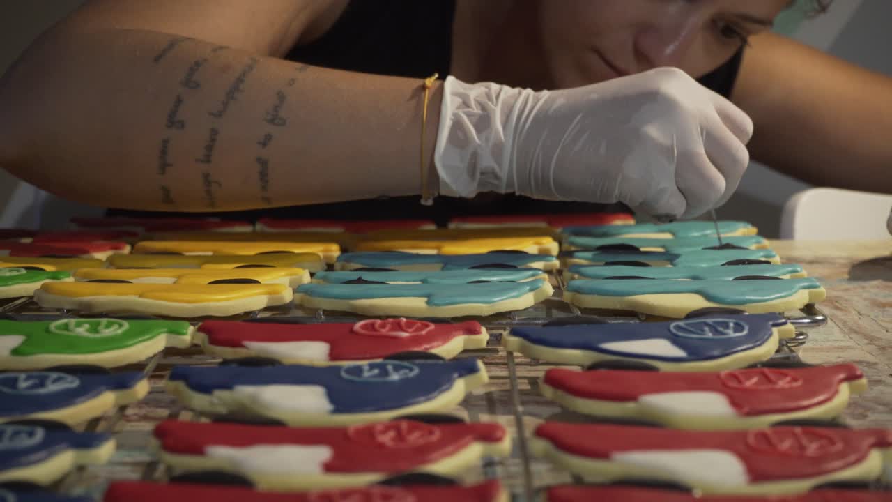 Woman decorates homemade vehicle shaped cookies with sugar icing