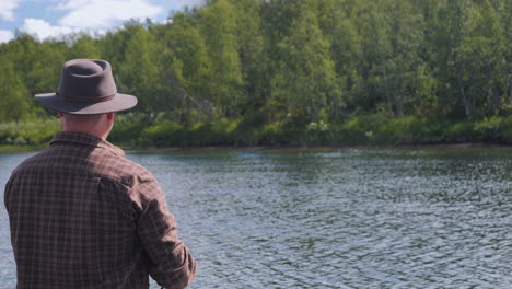 Fisherman-fishing-in-Alaska,-over-the-shoulder-view