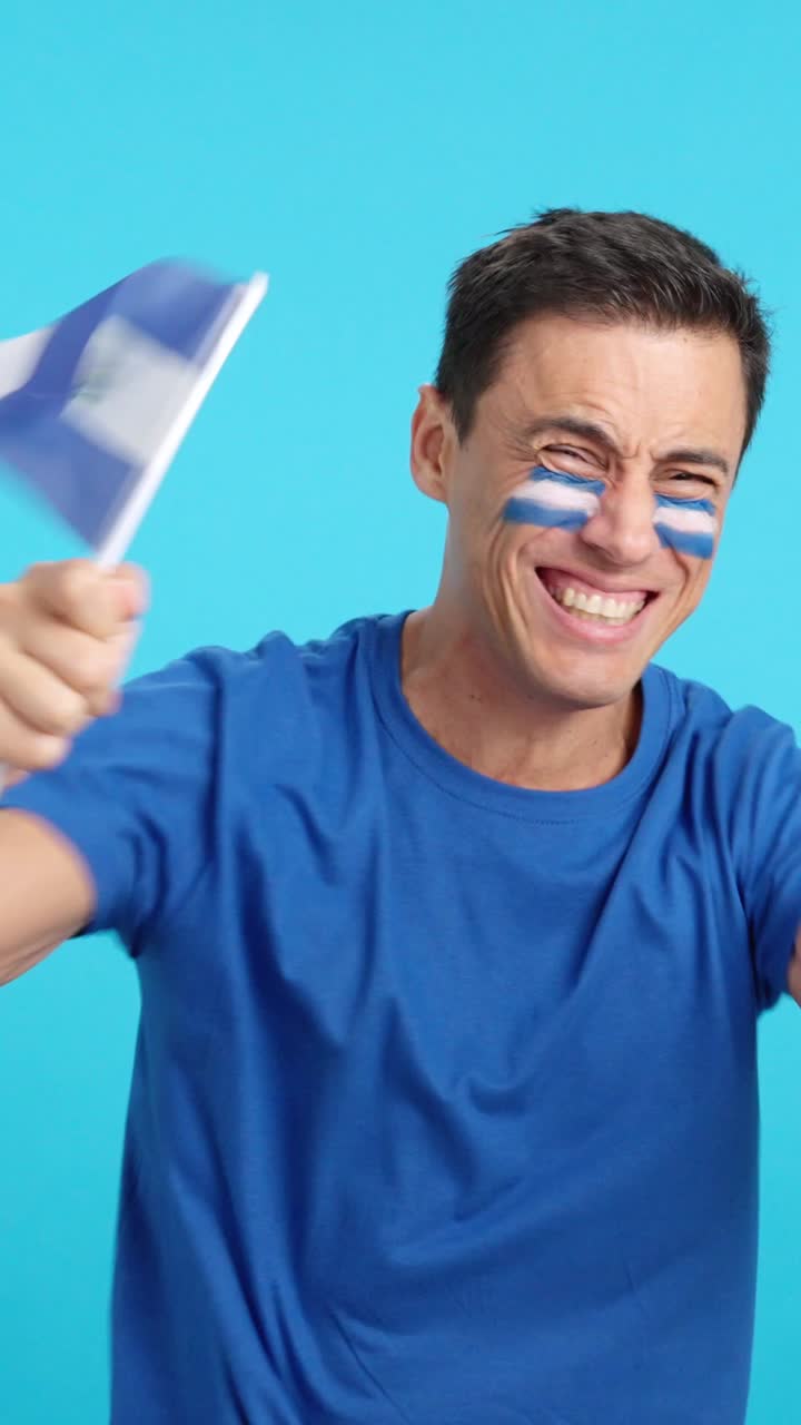 Man cheering for El Salvador screaming and waving a national flag
