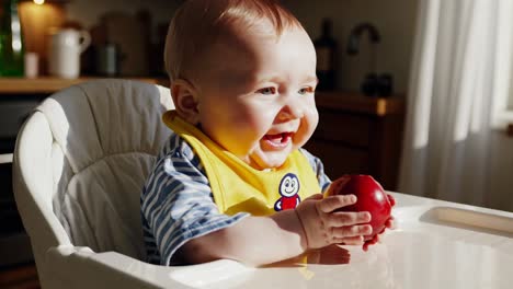 baby eating an apple in a high chair