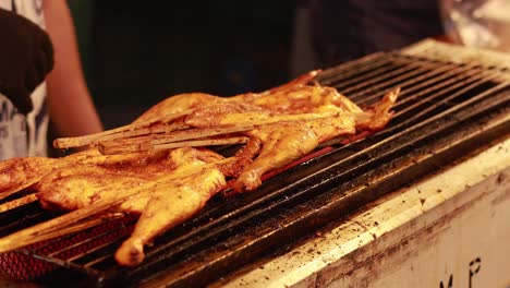 chicken being grilled at a street food market