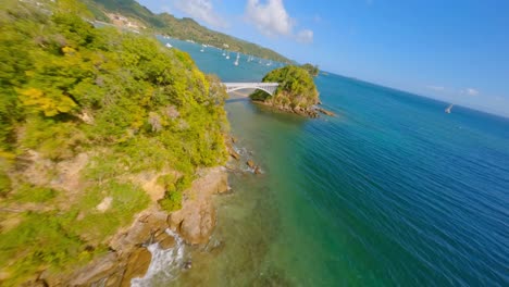 vuelo fpv dinámico en los puentes de la bahía de samana, en una tarde soleada, agua azul turquesa, catamaranes a la vista