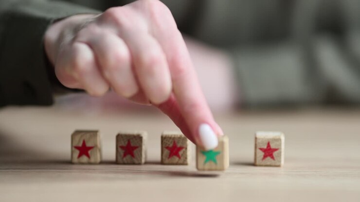 Female hand puts ahead wooden cube with green star as leader