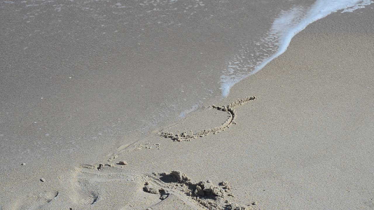 Cuore nella sabbia. Cuore trafitto da una freccia nella sabbia