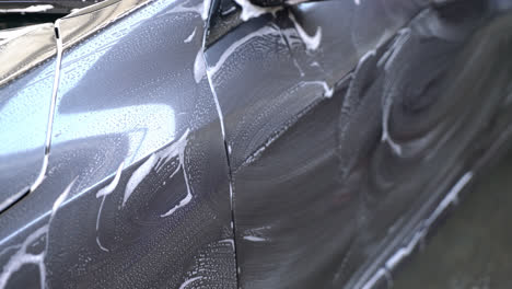 close-up grey car with washing foam