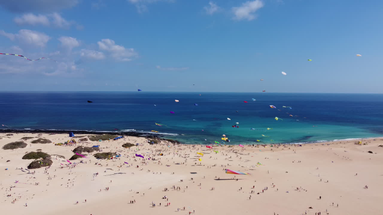 화창한 날 바람을 타고 날아가는 관광객들에 의해 모래사장을 날아다니는 다채로운 연