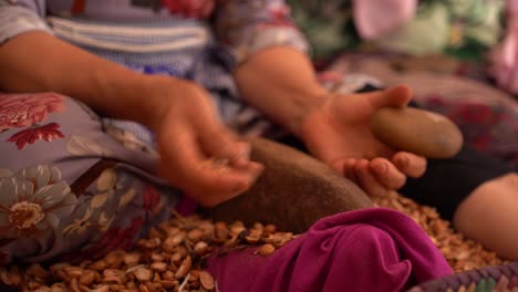 A-close-up-of-hands-beating-up-seeds-in-order-to-produce-arganiste-oil,-Morocco