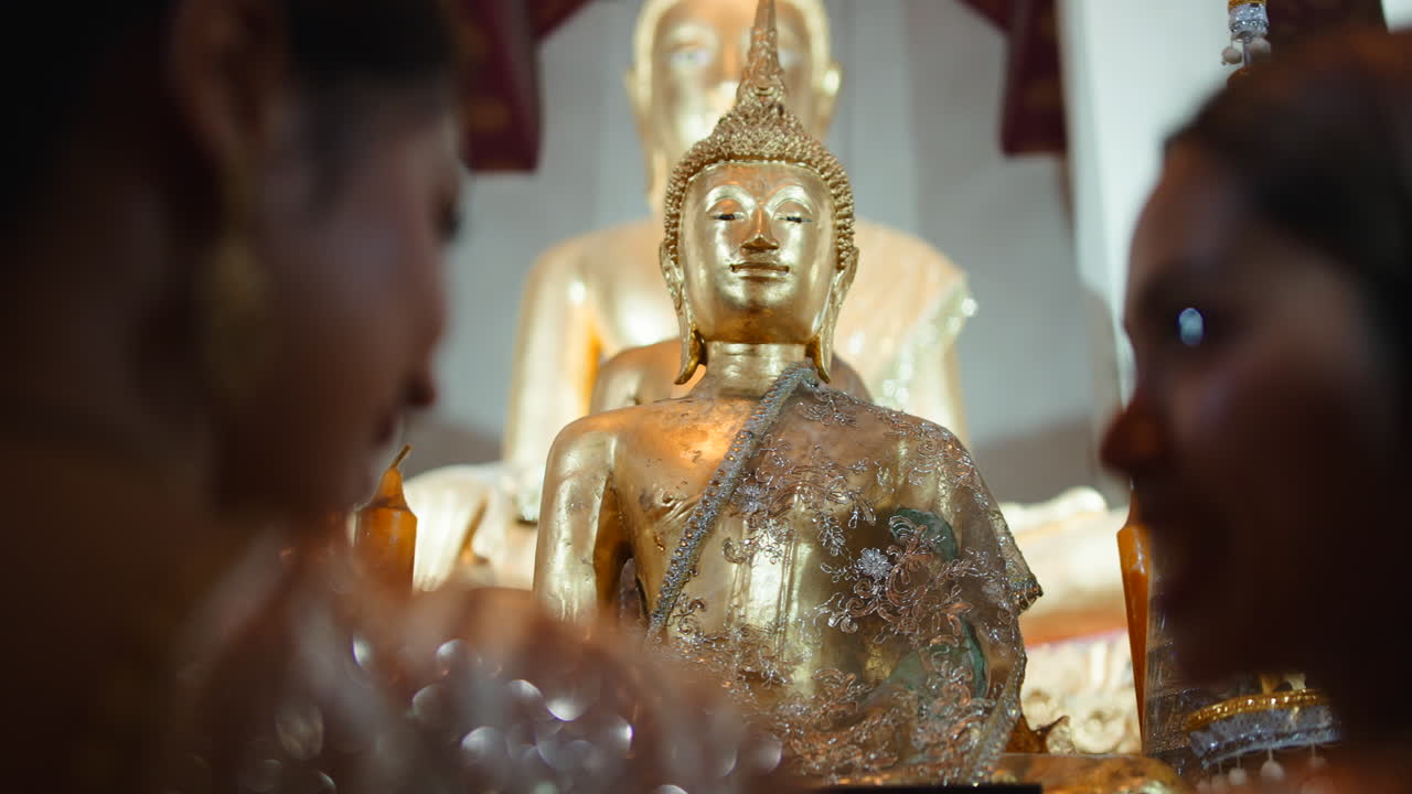 Statua dorata del Buddha con donne