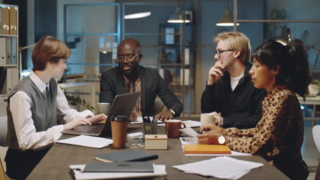 multiethnic colleagues talking on business meeting at night