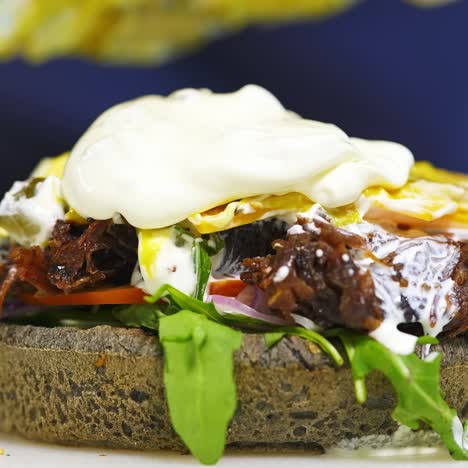 preparation of fresh burger. mayonnaise is poured on a delicious meal. professional cook making hamburger in a restaurant. close-up. pleasant appetite
