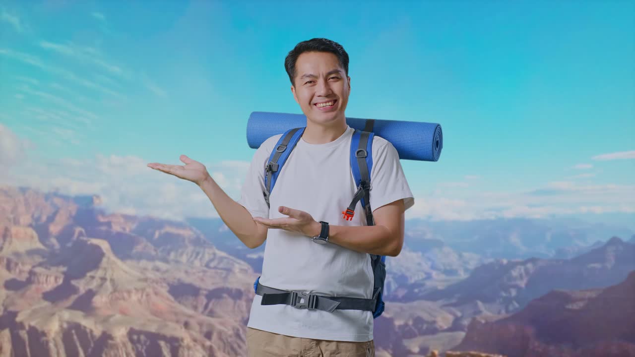 Asian Male Hiker With Mountaineering Backpack Smiling And Pointing To Side While Traveling At The Top Of Mountain