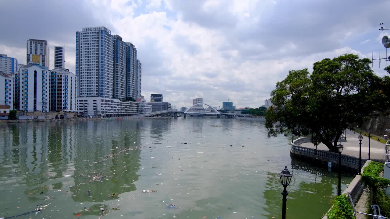Urban view of Pasig River with floating plastic trash and debris pollution in capital city of Manila Philippines