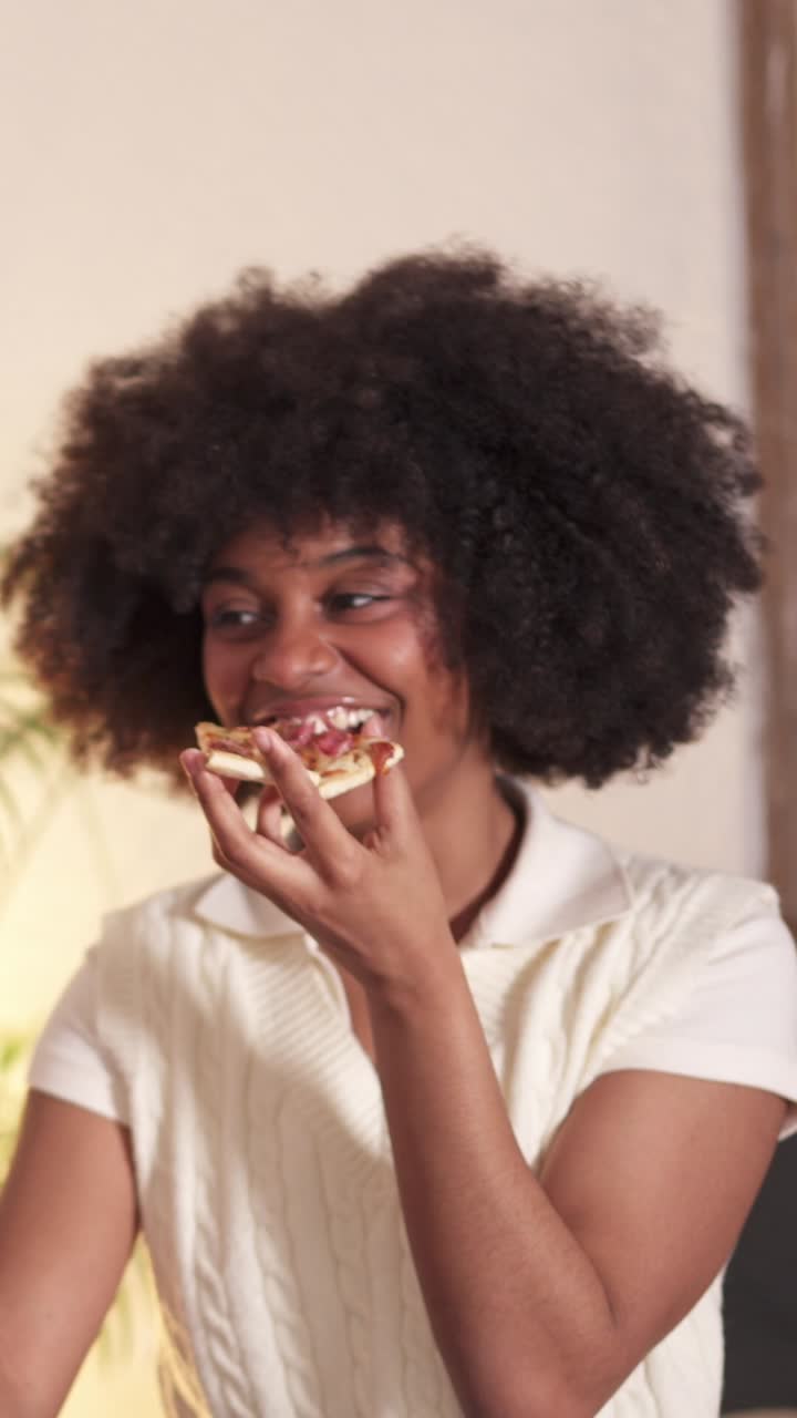 A happy woman enjoying a slice of pizza