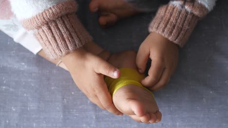 child wrapping ankle with bandage