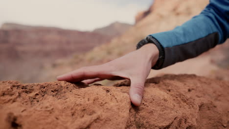 Hombre-Corriendo-Su-Mano-A-Lo-Largo-De-La-Superficie-Rocosa-De-La-Tierra-En-Apreciación-Del-Mundo-Y-El-Medio-Ambiente