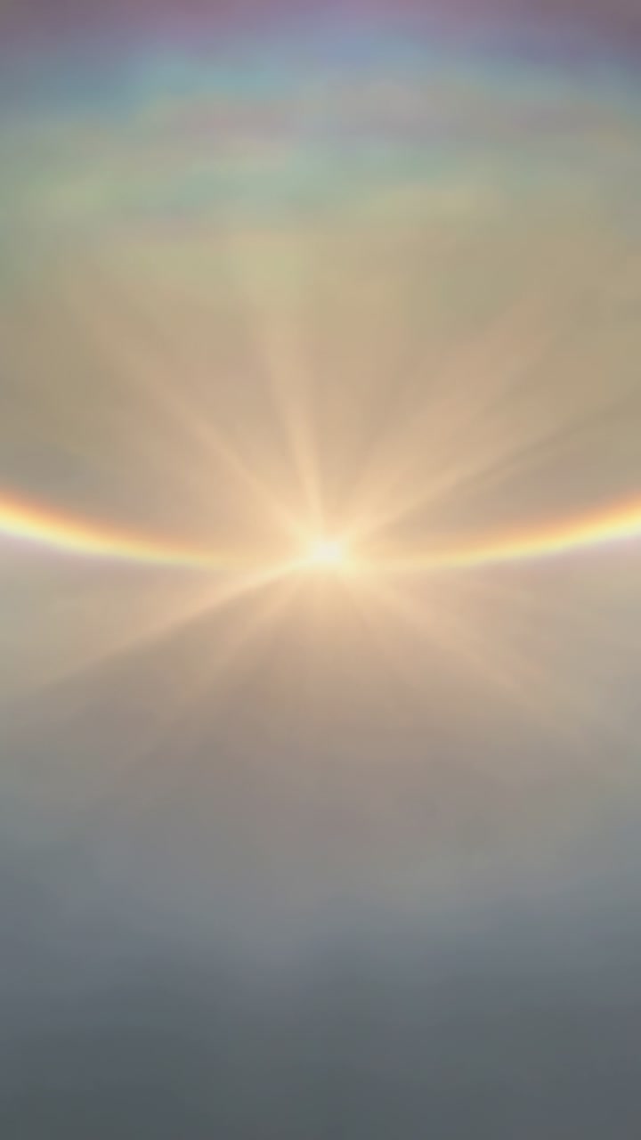 Vertical video: Capturing sun growing and forming color arc with radial rays in cirrus haze by cam