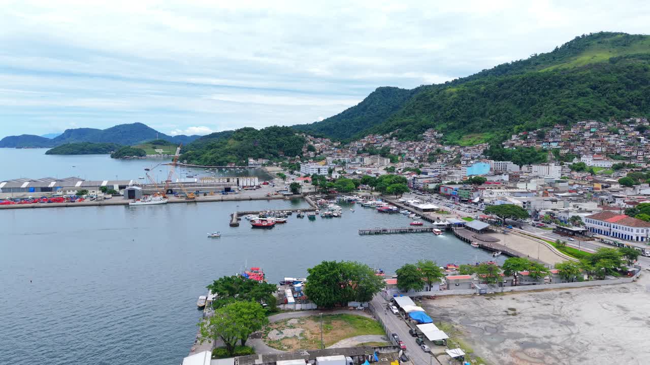 Cảng Angra dos Reis ở Rio de Janeiro, Brazil, với khu vực Marina Piratas, lối đi dạo ven sông dọc theo Đại lộ Júlio Maria và nơi neo đậu thuyền nhỏ trong một vịnh kín gió, cảnh quay tiết lộ từ drone bay về phía trước