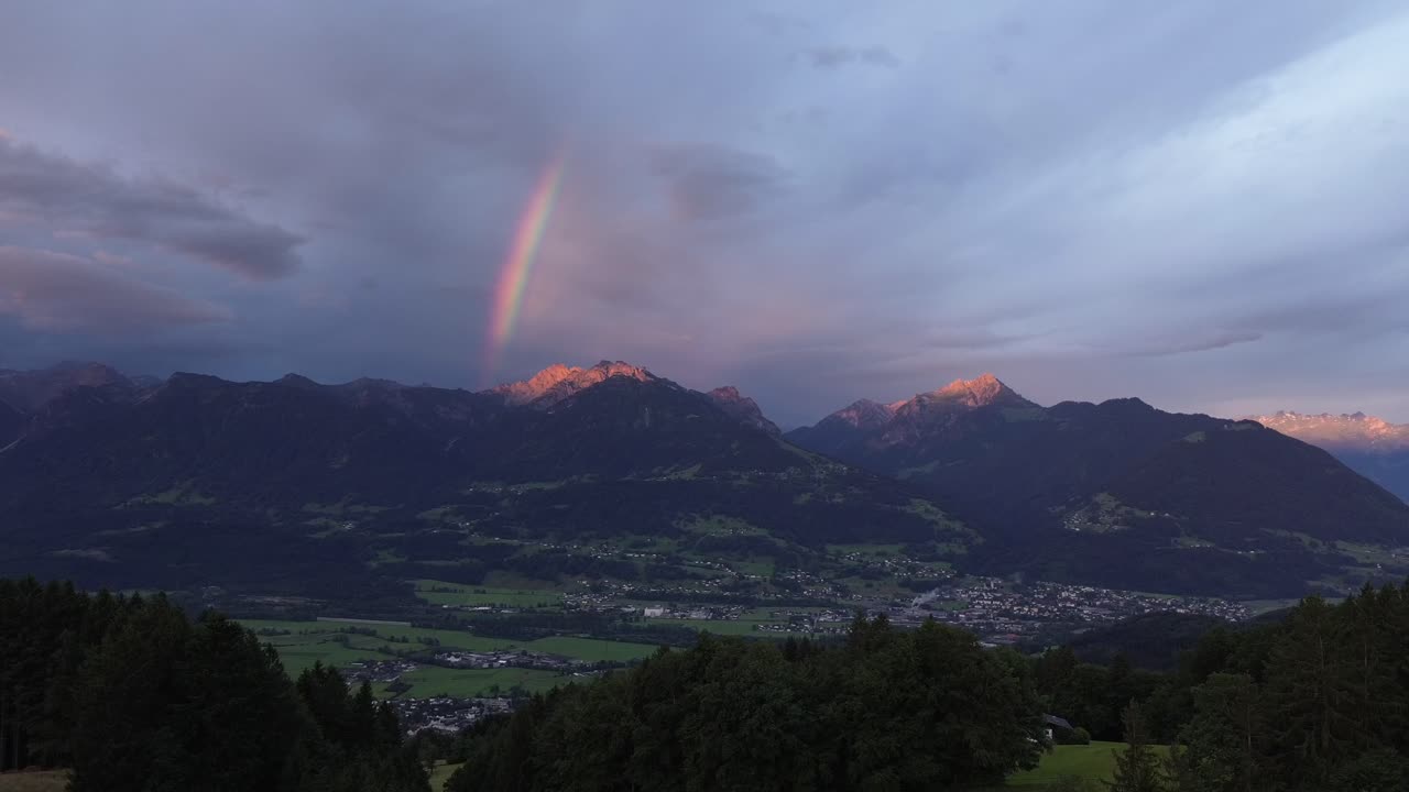 Aerial view of Mountain Range in Austria with Rainbow in Background