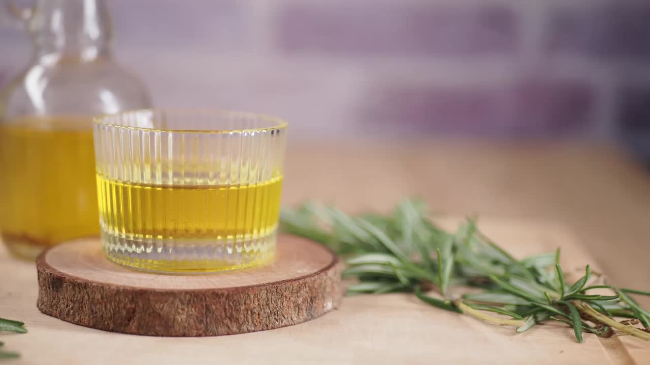 Naturlig rosmarinolie i et glas og en flaske