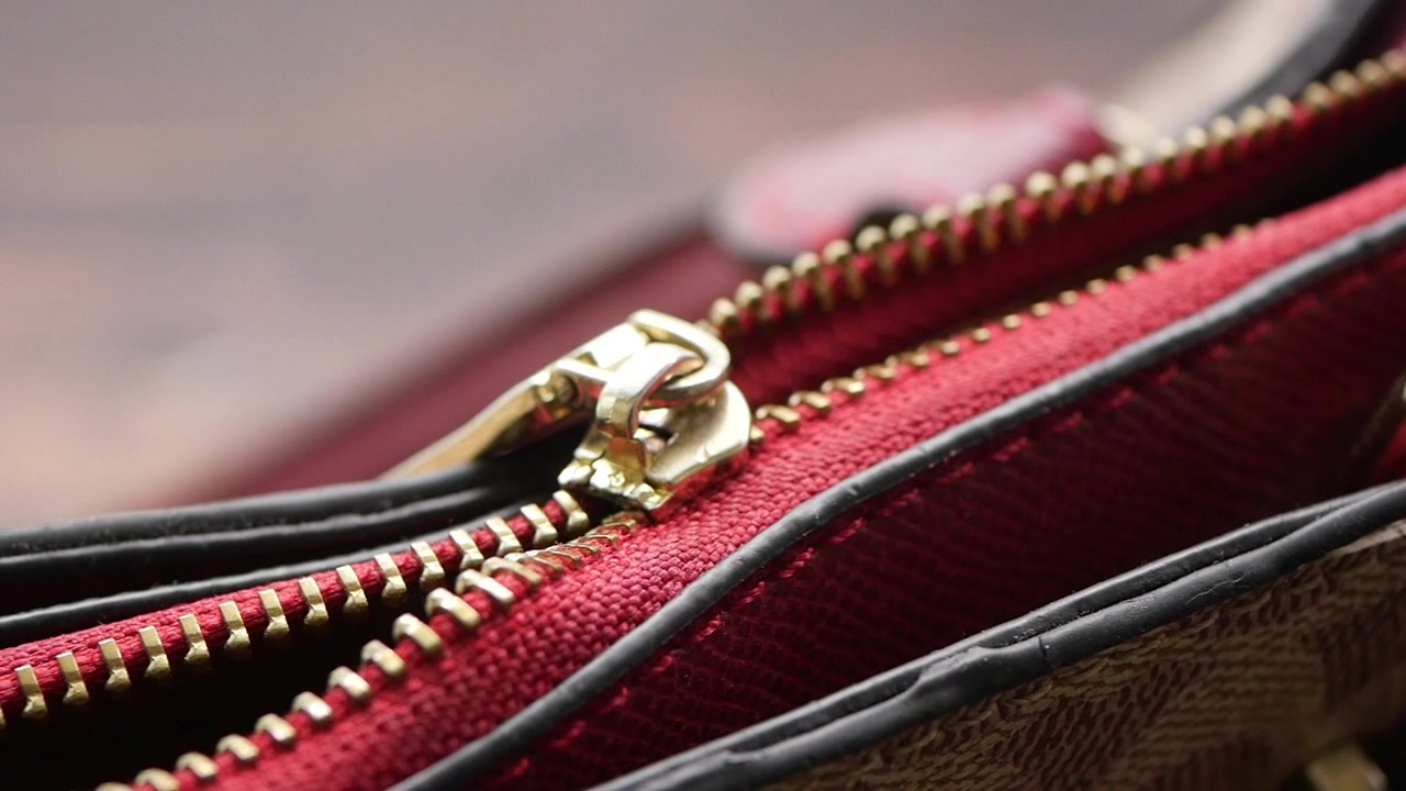 Primo piano di una cerniera dorata su una borsa di design