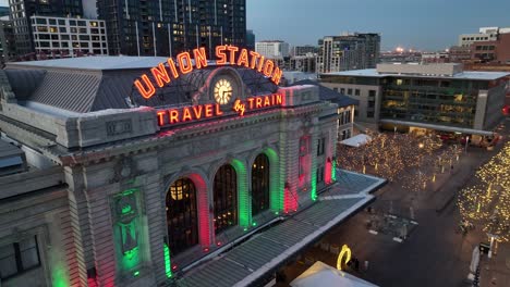 Cinematic-parallax-drone-shot-highlighting-Union-Station-historic-architectural-building-and-street-illuminated-with-Christmas-lights,-Denver,-Colardo