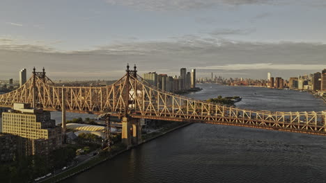 NYC-New-York-Luftaufnahme-V381,-Niedrige-Überführung-über-Die-Queensboro-Bridge,-Erfasst-Den-Verkehr-Beim-Überqueren-Des-East-River,-Roosevelt-Island-Und-Die-Stadtansicht-Von-Long-Island-City-Bei-Sonnenaufgang-–-Aufgenommen-Mit-Mavic-3-Pro-Cine-–-September-2023