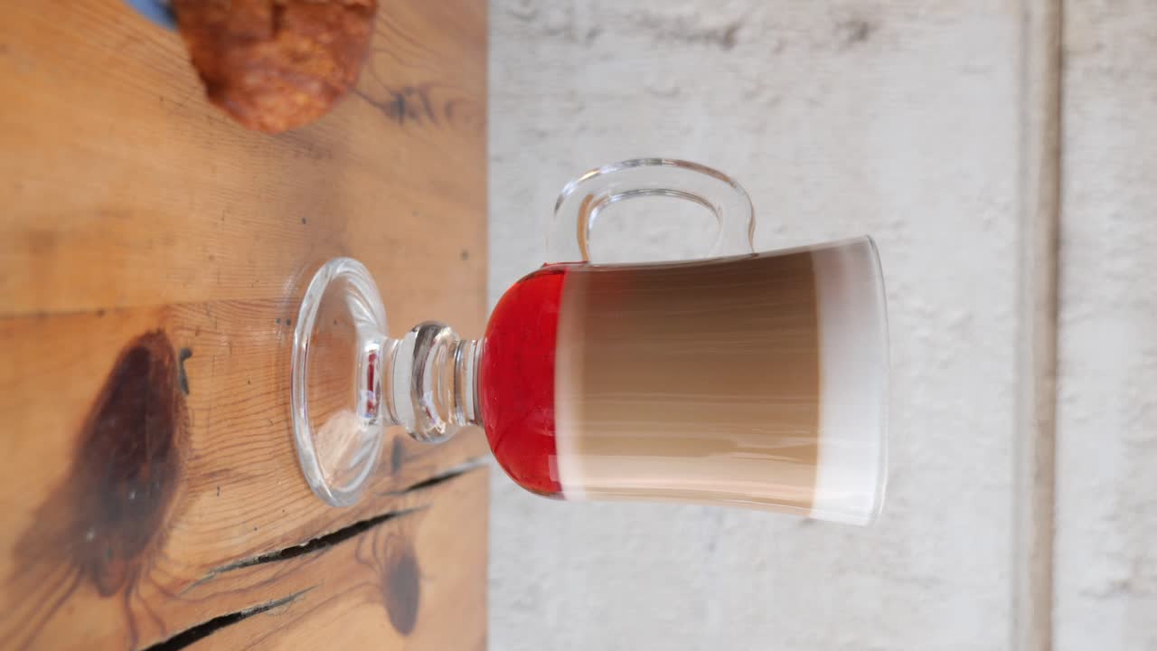 Layered Coffee Drink and Croissant on a Wooden Table