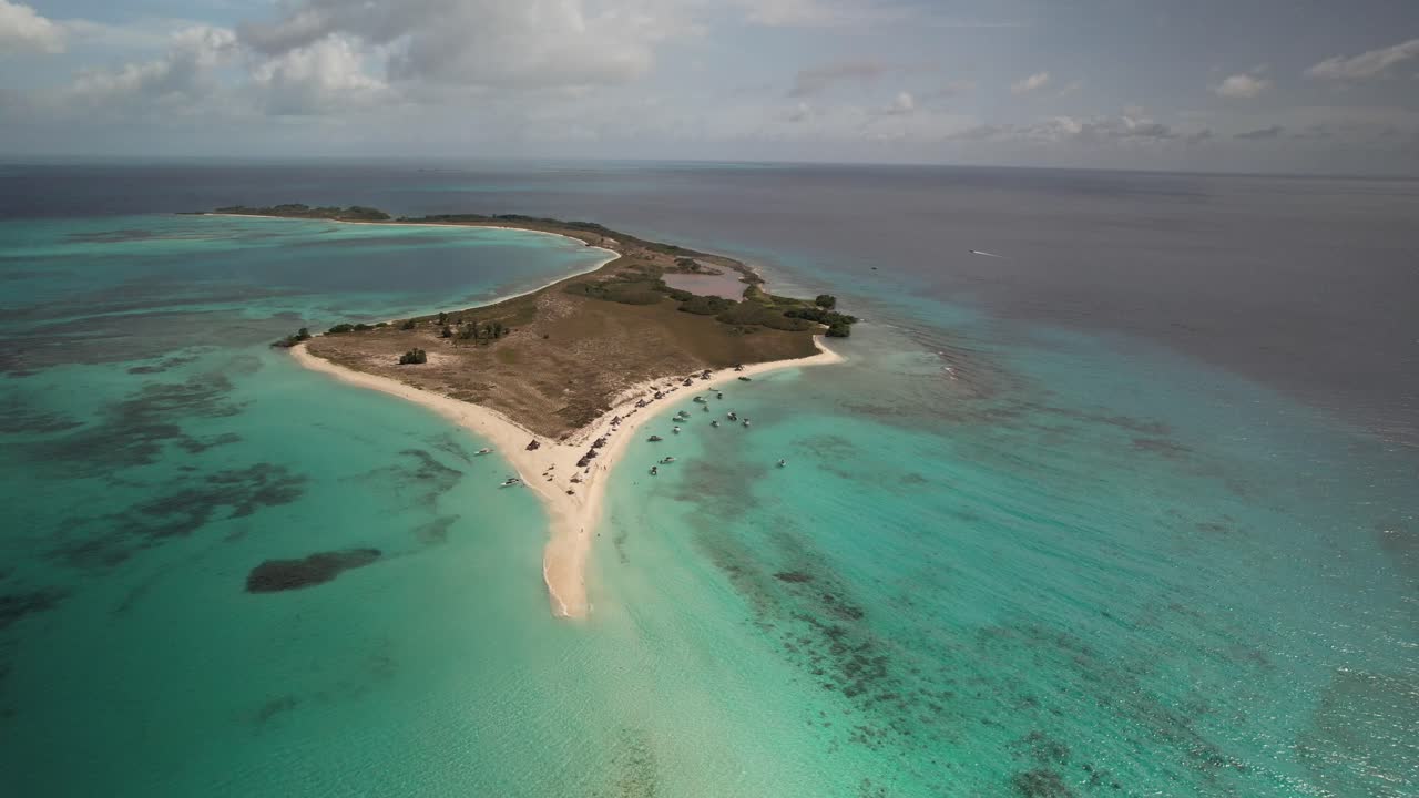 A turquoise isthmus surrounded by clear water and sandy beaches, aerial view