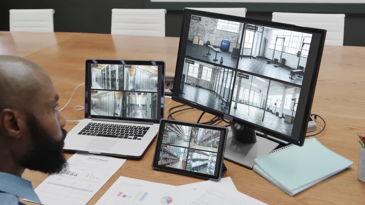 oficial de seguridad afroamericano viendo las vistas de las cámaras de cctv en pantallas de computadora, cámara lenta