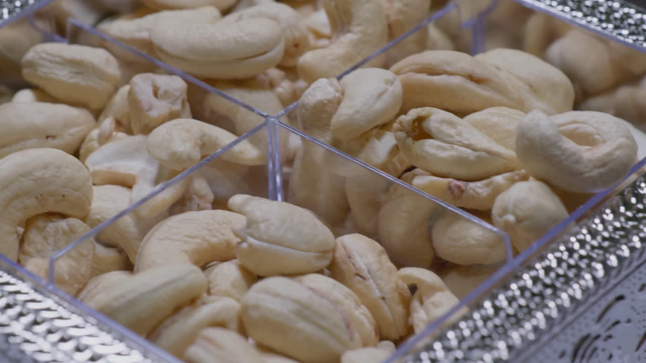 cashew nuts in a fancy silver plastic box, 4k, close up, push in shot