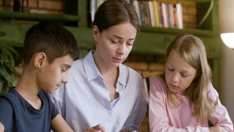 Young-happy-teacher-smiling-and-talking-to-little-kid