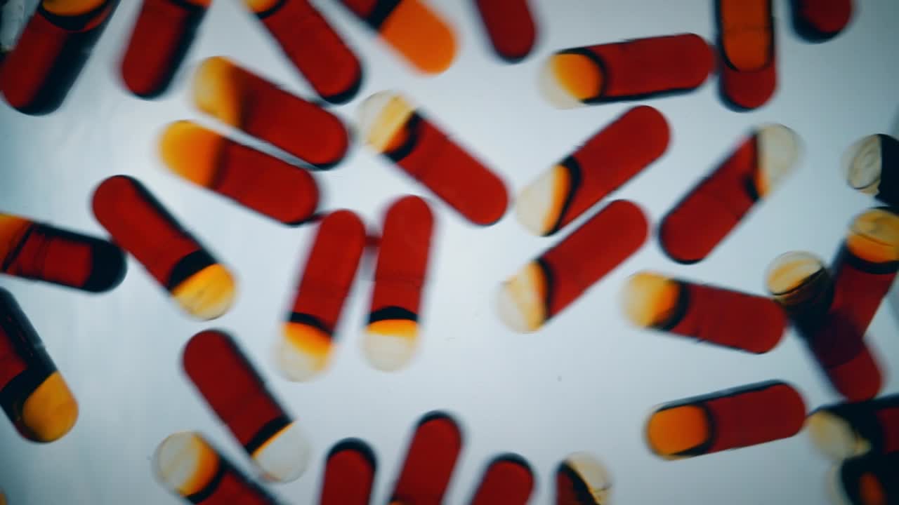 cápsulas de aceite de krill rojo rebotando sobre una superficie blanca, llenando el marco