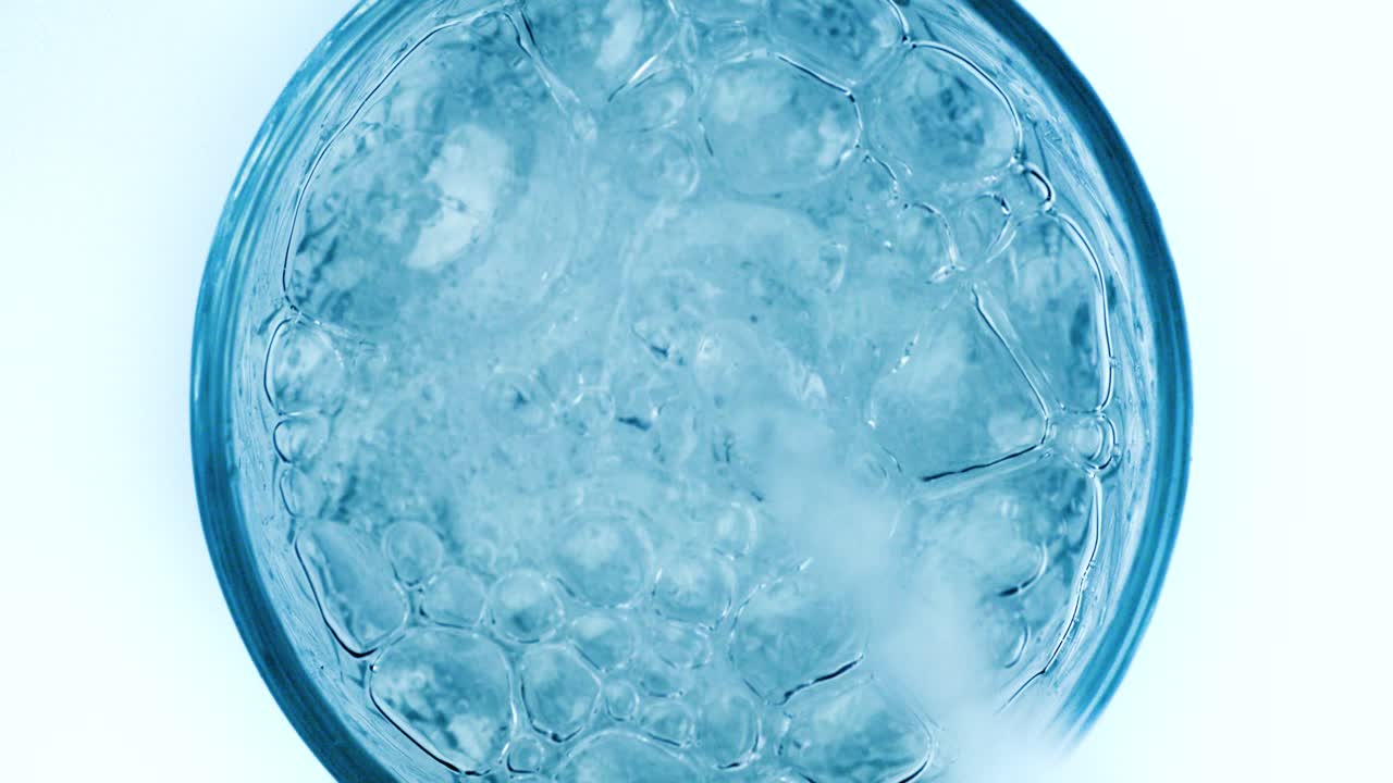 병에서 신선한 순수한 스파클링 물을 잔에 부어. 슈퍼 슬로우 모션으로 물에 거품이.