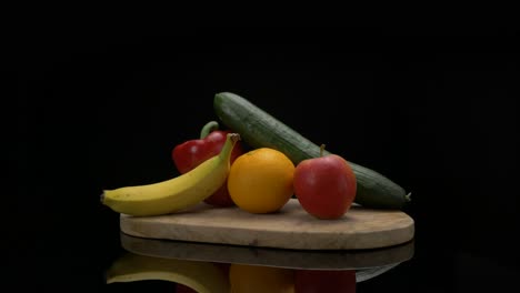 Arrangement-of-fruits-coming-into-frame-on-a-wooden-cutting-board