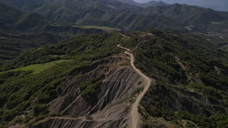 drone footage of winding dirt road through the picturesque trebeshinë-dhëmbel-nemërçkë mountain chain near permet, albania