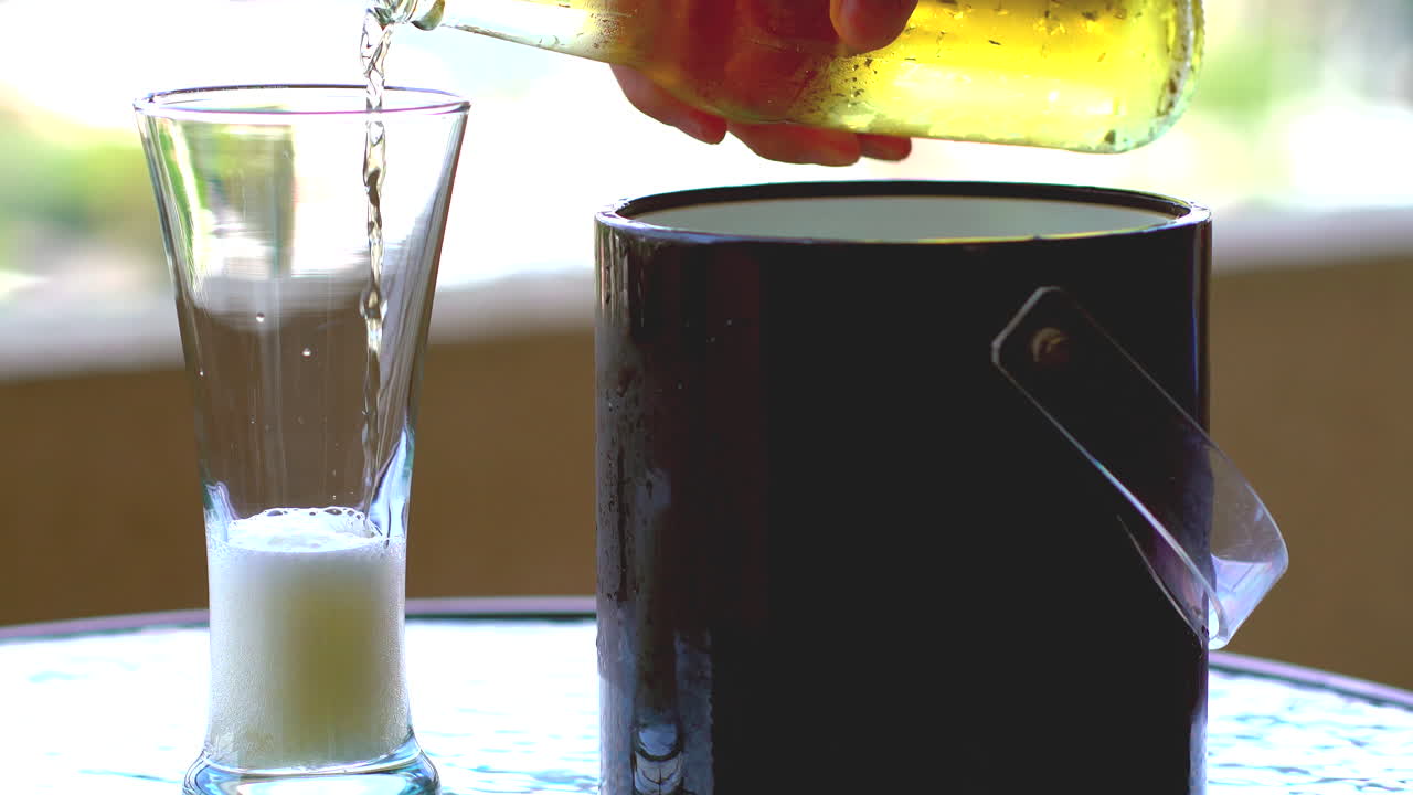 sirviendo cerveza fría con botella en casa