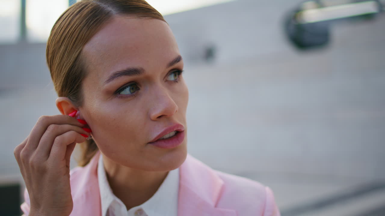 mujer de negocios auriculares llamando a los socios sentado en la calle de cerca. trabajo del gerente