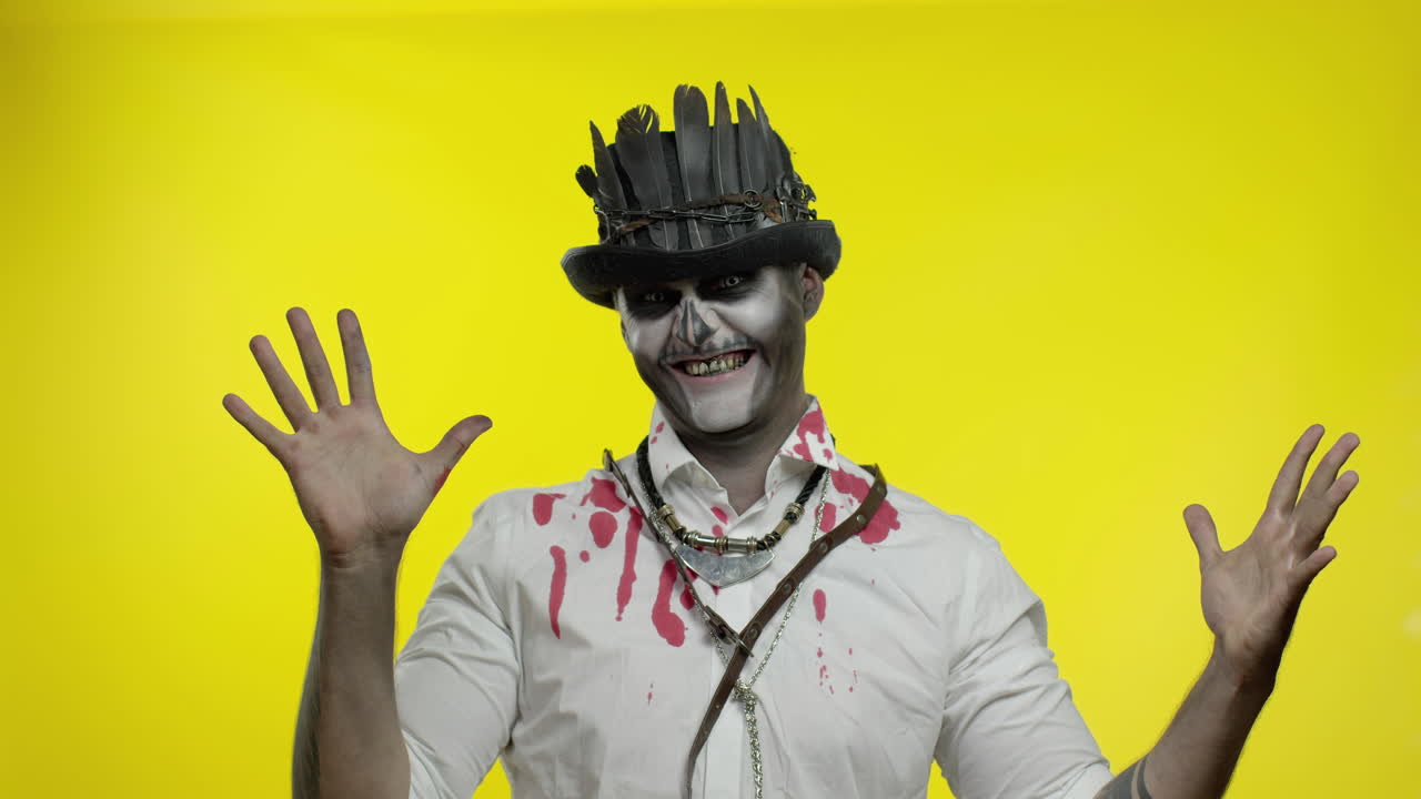 un hombre loco con un horrible maquillaje de esqueleto de halloween aparece desde abajo, tratando de asustar