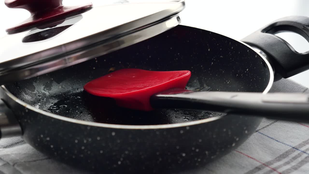 Empty cooking pan with lid and spatula