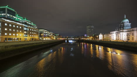 time lapse of custom house historical building in dublin city at night with reflection on liffey river in ireland