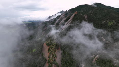 cinematic aerial through mountain fog reveals flatirons of chautauqua park